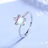 Une bague en argent avec un motif de licorne. La licorne a une crinière et une queue arc-en-ciel. La bague est ajustable.