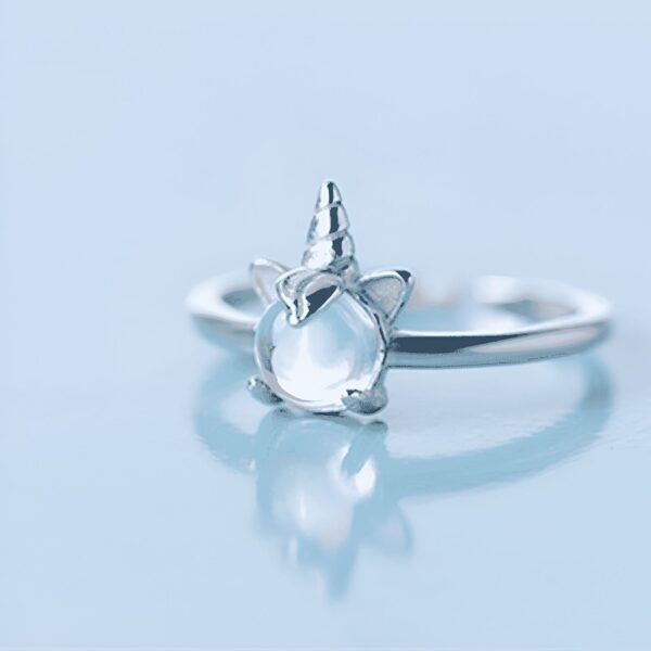 Bague argentée avec un motif de licorne, présentant une petite corne spirale et des oreilles pointues, avec une pierre lumineuse au centre. Bijou fantaisie pour les amoureux des créatures mythiques., 45501845438719,45501845471487,45501845504255,45501845537023,45501845569791,45501845602559,45501845635327,45501845668095,45501845700863,45501845733631,45501845766399,45501845799167,45501845831935,45501845864703,45501845897471 | Licorne Shop