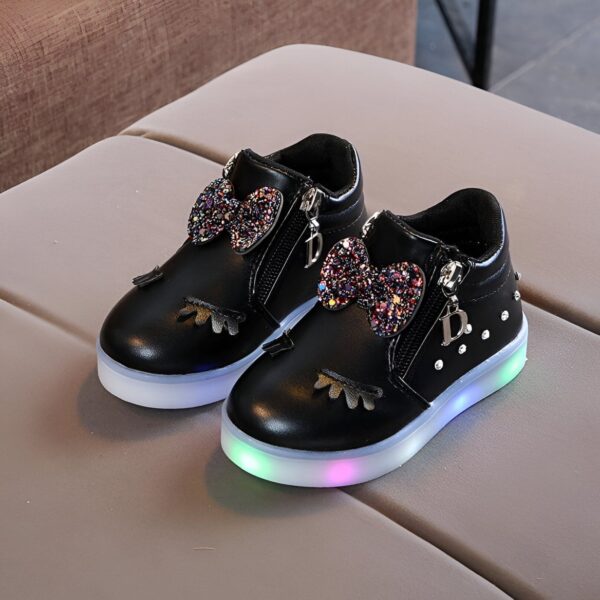 baskets-licorne-lumineuses-noires-1a.jpg Une paire de chaussures noires pour enfant avec des nœuds pailletés et des lumières LED dans les semelles.