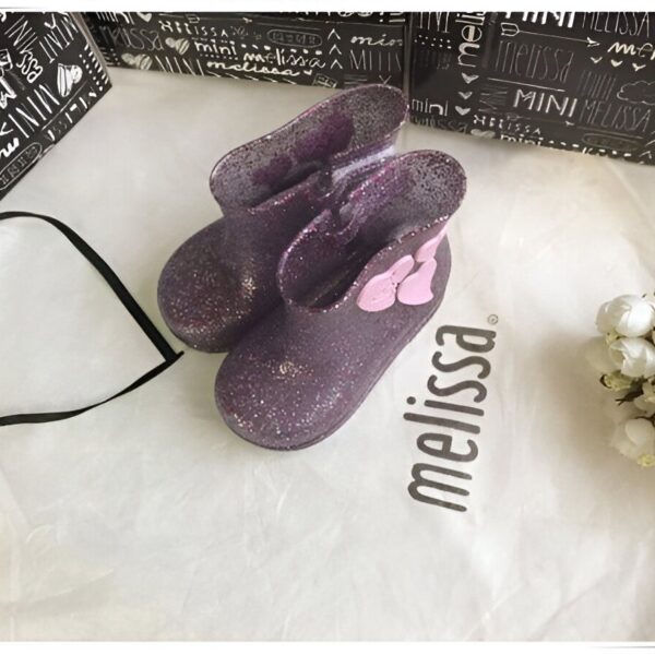 bottes-licorne-impermeables-en-forme-de-coeur-1a.jpg Bottes de pluie violettes à paillettes Mini Melissa sur sac en tissu blanc avec logo Melissa, emballage et fleurs blanches. Chaussures pour enfant tendance et mignonnes., 45501102358783,45501102391551,45501102424319,45501102457087,45501102489855,45501102522623,45501102555391,45501102588159,45501102620927 | Licorne Shop