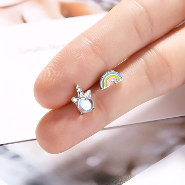 boucles-d-oreilles-licorne-arc-en-ciel-kawaii-3a.jpg Une image de deux boucles d'oreilles en forme de licorne et d'arc-en-ciel. Les boucles d'oreilles sont en argent et ont une forme de licorne et d'arc-en-ciel. La licorne a une crinière et une queue arc-en-ciel. L'arc-en-ciel a les couleurs suivantes : rouge, orange, jaune, vert, bleu, indigo et violet.