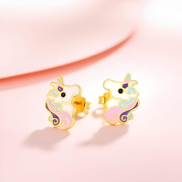Une paire de boucles d'oreilles en forme de licorne en or avec des détails en émail rose, violet et bleu.