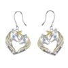 boucles-d-oreilles-licorne-mere-et-fille-pendante-1a.jpg Une paire de boucles d'oreilles en forme de cœur avec deux licornes, une grande et une petite. La grande licorne a une crinière et une queue dorées, et la petite licorne a une crinière et une queue argentées. Les deux licornes ont des yeux bleus. Le cœur est en argent et est décoré de zircons cubiques. Les boucles d'oreilles sont en argent sterling 925 et sont hypoallergéniques.