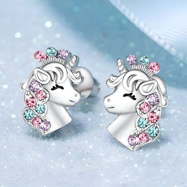 boucles-d-oreilles-licorne-mignonne-1a.jpg Une paire de boucles d'oreilles en forme de licorne en argent avec des cristaux roses, bleus et violets.