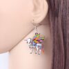 boucles-d-oreilles-licorne-pendantes-rouges-1a.jpg Une image d'une boucle d'oreille en forme de licorne. La licorne est blanche avec une crinière et une queue arc-en-ciel. Elle a des ailes multicolores et une corne dorée. La boucle d'oreille est en métal argenté.