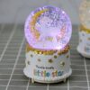 boule-a-neige-licorne-et-paysage-canadien-1a.jpg Boule à neige musicale avec licorne et lune dorée. La base blanche décorée d'étoiles dorées porte l'inscription "Twinkle twinkle little star". Éclairage intérieur violet. Décoration féérique pour chambre d'enfant., 45501133553919 | Licorne Shop