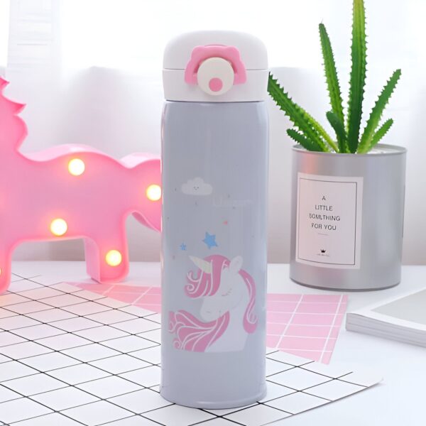bouteille-d-eau-licorne-enfant-1a.jpg Gourde thermos décorée d'un motif de licorne rose et blanche sur fond gris, avec un bouchon blanc orné d'une fleur rose. Un cactus et une veilleuse licorne rose sont visibles en arrière-plan., 45501178249471 | Licorne Shop