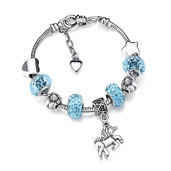Un bracelet avec des breloques en forme de cœur, de fleur, d'étoile et de licorne. Les breloques sont en cristal bleu clair et le bracelet est en argent.