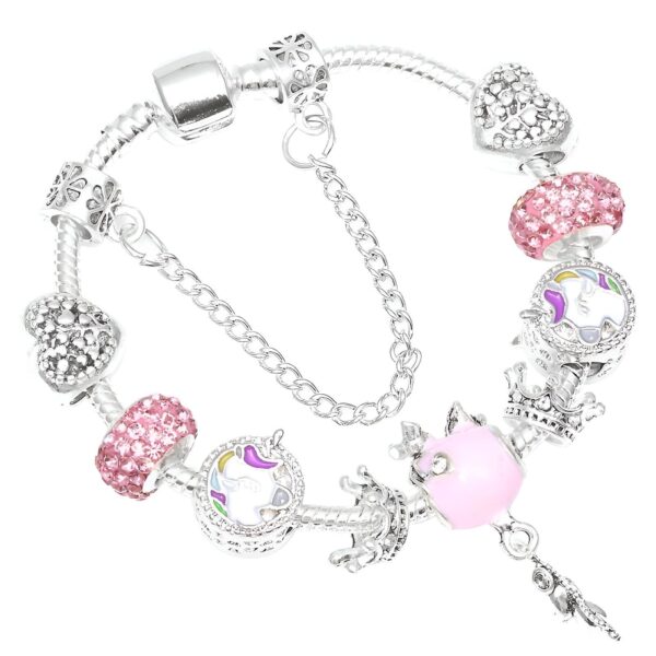 bracelet-licorne-charms-1a.jpg Un bracelet en argent avec des breloques en forme de licorne, de couronne et de cœur. Les breloques sont roses et blanches.
