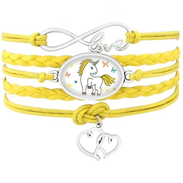 Un bracelet en cuir jaune avec un pendentif en forme de licorne et un pendentif en forme de cœur. Le bracelet est également décoré de deux breloques en forme d'étoile et de deux breloques en forme de lune.