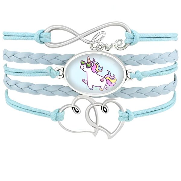 L'image montre un bracelet en cuir bleu avec un pendentif en forme de licorne. La licorne est représentée avec des lunettes de soleil et une crinière arc-en-ciel. Le bracelet est également décoré de deux cœurs en métal.