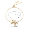 bracelet-licorne-en-zircone-cubique-5a.jpg Un bracelet avec un pendentif licorne en plaqué or. La licorne a des ailes et une crinière arc-en-ciel. Le bracelet est réglable de 18 à 24 cm.