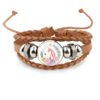 bracelet-licorne-enroule-en-cuir-marron-1a.jpg Bracelet multicouche en cuir tressé marron, avec une image d'une tête de licorne rose et blanche entourée de fleurs. Fermoir ajustable avec cordelette. Bijou fantaisie pour femme, style bohème. Accessoire de mode tendance., 45501397270783 | Licorne Shop