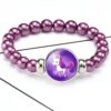 bracelet-licorne-fantaisie-a-perles-bordeaux-1a.jpg Bracelet de perles violettes avec pendentif rond affichant un dessin de licorne violette. Bijou fantaisie pour enfants., 45501400580351 | Licorne Shop