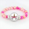 Un bracelet avec des perles roses et blanches et un pendentif en forme de licorne avec des fleurs dans les cheveux.