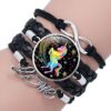bracelet-licorne-tresse-fille-2a.jpg Le bracelet est en cuir noir et comporte une breloque en forme de licorne. La licorne est représentée avec une crinière et une queue arc-en-ciel. Le bracelet est également orné de étoiles et de lunes.