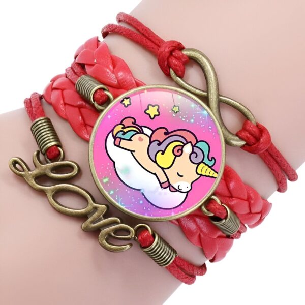 bracelet-licorne-tresse-fille-7a.jpg L'image montre un bracelet en cuir rouge avec un pendentif en forme de licorne endormie sur un nuage. Le bracelet est également décoré de deux breloques en forme de cœur et d'une breloque en forme d'infini.