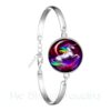 bracelet-manchette-licorne-fantaisie-1a.jpg Bracelet argenté avec médaillon illustrant une licorne arc-en-ciel cabrée sur fond rouge et violet. Bijou fantaisie pour femme avec fermoir réglable. Accessoire tendance et original., 45501399204095 | Licorne Shop