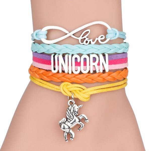 bracelet-pendentif-licorne-3a L'image montre un bracelet en cuir avec un pendentif en forme de licorne. Le bracelet est composé de quatre brins de cuir de couleurs différentes : bleu clair, rose, orange et jaune. Le pendentif est en métal argenté et représente une licorne.