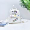 cartable-licorne-arc-en-ciel-blanc-1a Un sac à dos blanc avec une image de licorne ailée et une étoile filante arc-en-ciel.