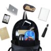cartable-licorne-chevaux-blancs-enfant-1a.jpg L'image montre un sac à dos noir avec plusieurs compartiments. Il y a un ordinateur portable, une tablette, un téléphone portable, un stylo, un cahier, un parapluie et une trousse. Le sac à dos est ouvert et on peut voir l'intérieur.