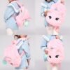 Une petite fille porte un sac à dos en peluche rose en forme de licorne. Le sac à dos a une crinière et une queue arc-en-ciel, ainsi qu'une grande poche zippée. La petite fille porte une chemise en jean et des jeans.