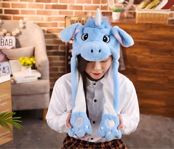 chapeau-licorne-chaud-pour-filles-en-hiver-1a.jpg Une femme portant un bonnet licorne bleu avec des oreilles tombantes et des pattes de fourrure pendantes., 45501624451327 | Licorne Shop