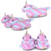 Une paire de pantoufles licorne en peluche rose et blanche avec une corne dorée et des ailes arc-en-ciel.