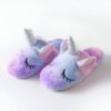 Une paire de pantoufles licorne en peluche violette et bleue avec une corne et des ailes argentées.