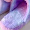 Une paire de pantoufles violettes et roses avec une doublure en fourrure blanche.