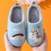 Une paire de pantoufles bleues en forme de licorne. Les pantoufles sont en peluche et ont une semelle antidérapante.