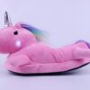 chausson-licorne-lumineux-rose-2a.jpg Une peluche licorne rose avec une corne argentée et une crinière arc-en-ciel. La peluche est éclairée par une lumière rose.