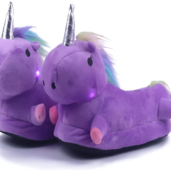 Une paire de pantoufles licorne violette avec une corne et une crinière arc-en-ciel. Les pantoufles sont éclairées par des LED.