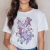Femme portant un T-shirt blanc avec un motif d'une pile de licornes colorées. Collier doré à plusieurs rangs. Style décontracté et fantaisiste., 45502308581631,45502308614399,45502308647167,45502308679935,45502308712703,45502308745471,45502308778239,45502308811007 | Licorne Shop