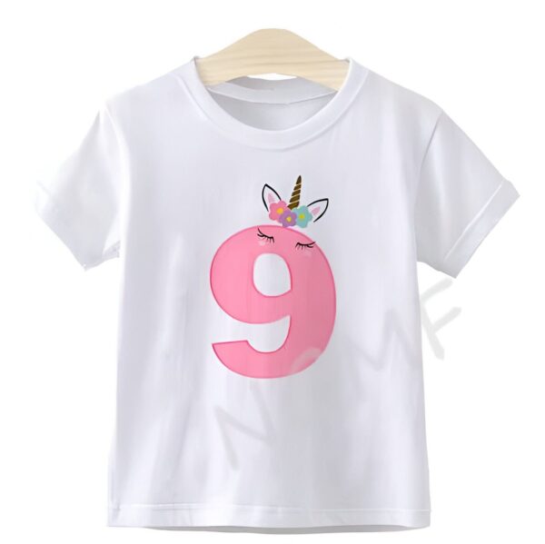 T-shirt blanc pour enfant, décoré d'un grand chiffre 9 rose orné d'un motif licorne avec des fleurs, suspendu à un cintre en bois. Idéal pour un anniversaire de 9 ans., 45502332141823,45502332174591,45502332207359,45502332240127,45502332272895,45502332305663,45502332338431,45502332371199 | Licorne Shop