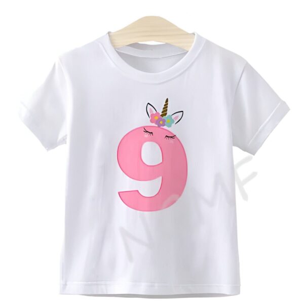 chemise-enfant-pour-anniversaire-9-ans-motif-licorne-coton-1a.jpg T-shirt blanc pour enfant, décoré d'un grand chiffre 9 rose orné d'un motif licorne avec des fleurs, suspendu à un cintre en bois. Idéal pour un anniversaire de 9 ans., 45502332141823,45502332174591,45502332207359,45502332240127,45502332272895,45502332305663,45502332338431,45502332371199 | Licorne Shop