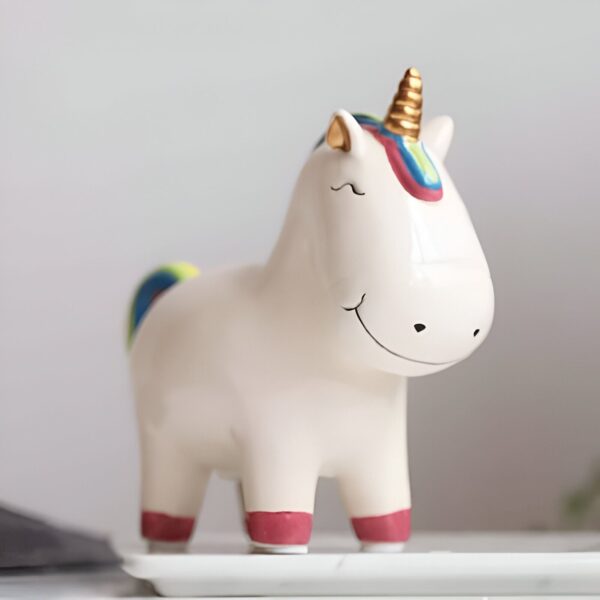 cochon-tirelire-licorne-originale-pour-enfant-walm-1a.jpg Figurine d'un licorne souriant en céramique blanche avec une corne dorée et une crinière et queue arc-en-ciel., 45501186441471 | Licorne Shop