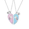 Deux colliers avec pendentifs en forme de cœur brisé. Les pendentifs sont roses et bleus et comportent chacun une licorne. Les colliers sont en argent.