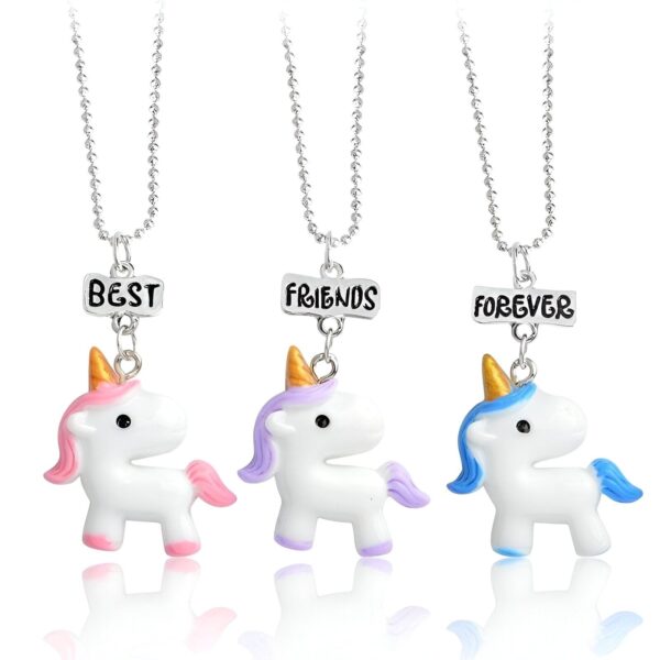 Trois colliers avec des pendentifs en forme de licorne. Les licornes sont blanches avec des crinières et des queues colorées. Les pendentifs sont attachés à des chaînes en argent.