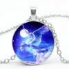 collier-licorne-envol-1a.jpg Un pendentif en forme de licorne ailée cabrée avec un collier en argent. La licorne est représentée avec une crinière et une queue arc-en-ciel, et est entourée d'étoiles et d'une lune.