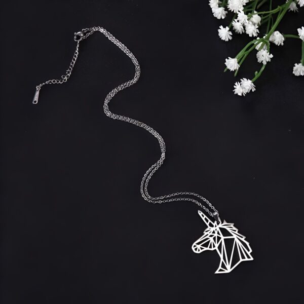 collier-licorne-geometrique-2a.jpg L'image représente un collier avec un pendentif en forme de licorne. La licorne est représentée de manière géométrique, avec des lignes et des angles. Le collier est en acier inoxydable.