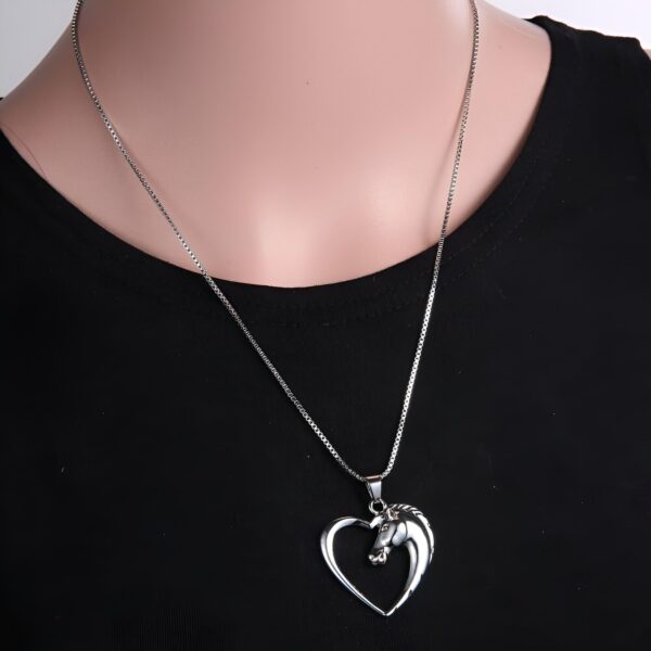 collier-licorne-homme-1a.jpg Un collier avec un pendentif en forme de cœur avec un cheval à l'intérieur.