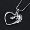 Un pendentif en forme de cœur en argent avec un cheval à l'intérieur.