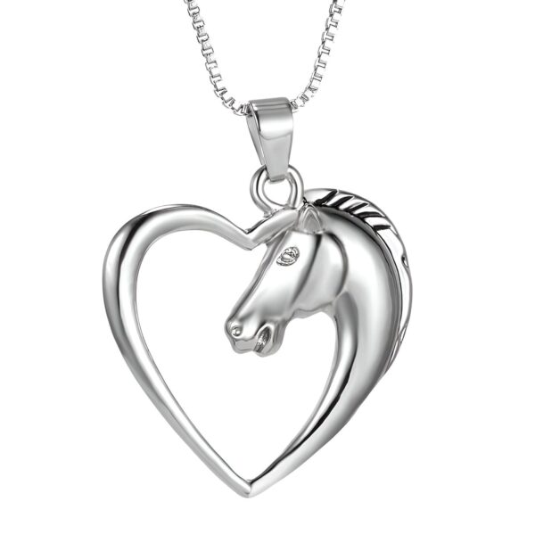 Un pendentif en forme de cœur avec un cheval à l'intérieur. Le cheval est représenté avec sa tête tournée vers la droite. Le pendentif est en métal argenté.