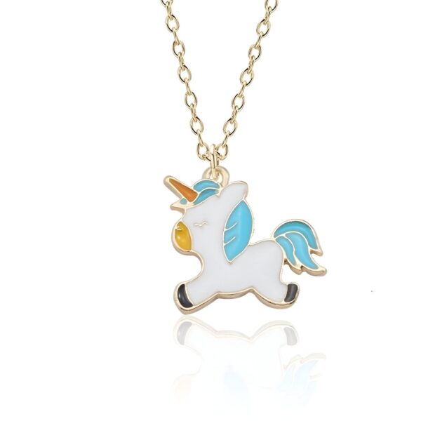 L'image représente un collier avec un pendentif en forme de licorne. La licorne est blanche avec une crinière et une queue bleues. Elle a une corne jaune et des yeux bleus. Le collier est en métal doré.
