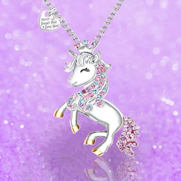 collier-licorne-princesse-3a.jpg L'image représente un collier avec un pendentif en forme de licorne. La licorne est blanche avec une crinière et une queue arc-en-ciel. Elle porte une couronne dorée sur la tête et un collier avec un cœur rose. Le pendentif est en métal argenté et est suspendu à une chaîne en argent.