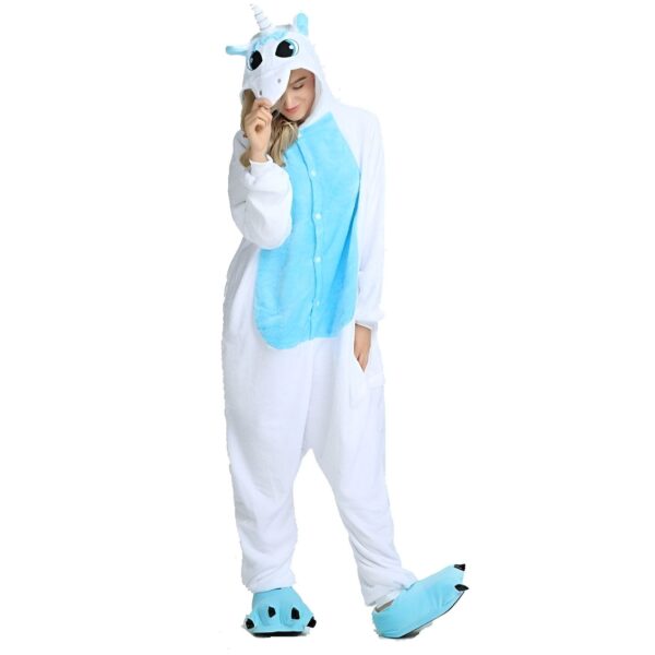 combinaison-licorne-femme-bleue-et-blanche-1a.jpg Une femme porte un pyjama licorne bleu et blanc. Le pyjama a une capuche avec une tête de licorne, des yeux bleus et une crinière rose. Il a également des ailes bleues et blanches et une queue rose. La femme est debout et sourit.