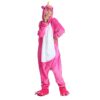 Une femme porte un pyjama licorne rose avec une capuche et des pieds en forme de pattes de licorne.