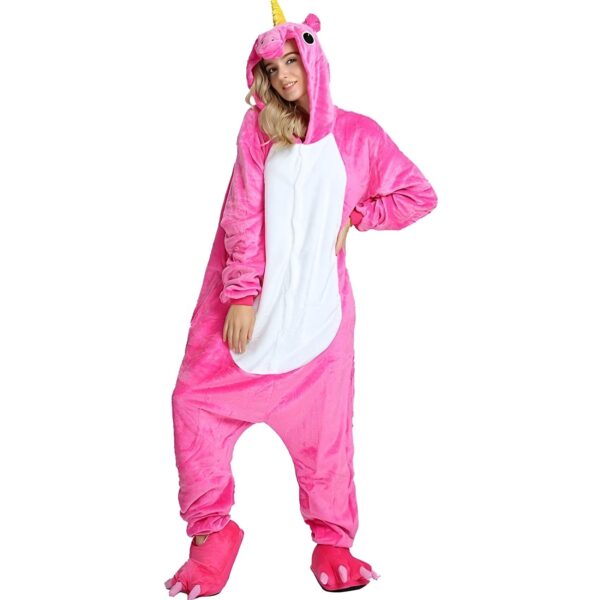 Une femme porte un pyjama licorne rose avec une capuche et des pieds en forme de pattes de licorne.