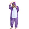 combinaison-licorne-femme-violette-3a.jpg Une femme porte un pyjama licorne violet avec une capuche. La combinaison est ouverte sur le devant et l'on peut voir qu'elle porte un legging blanc. Elle a les cheveux blonds et les yeux bleus. Elle est pieds nus.